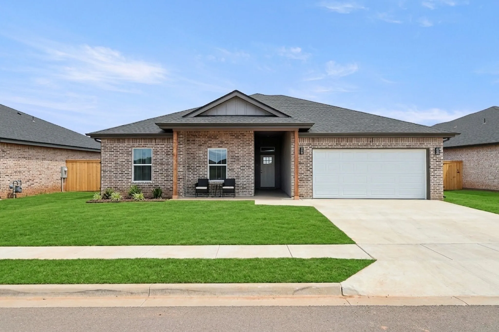 Brick exterior with a gabled roofline, concrete driveway, and a two-car garage