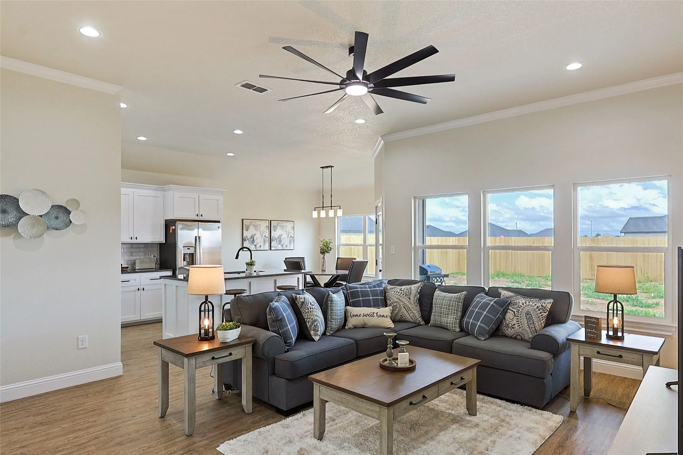 Open-concept living space featuring wood-finish flooring, recessed lighting, and a contemporary ceiling fan
