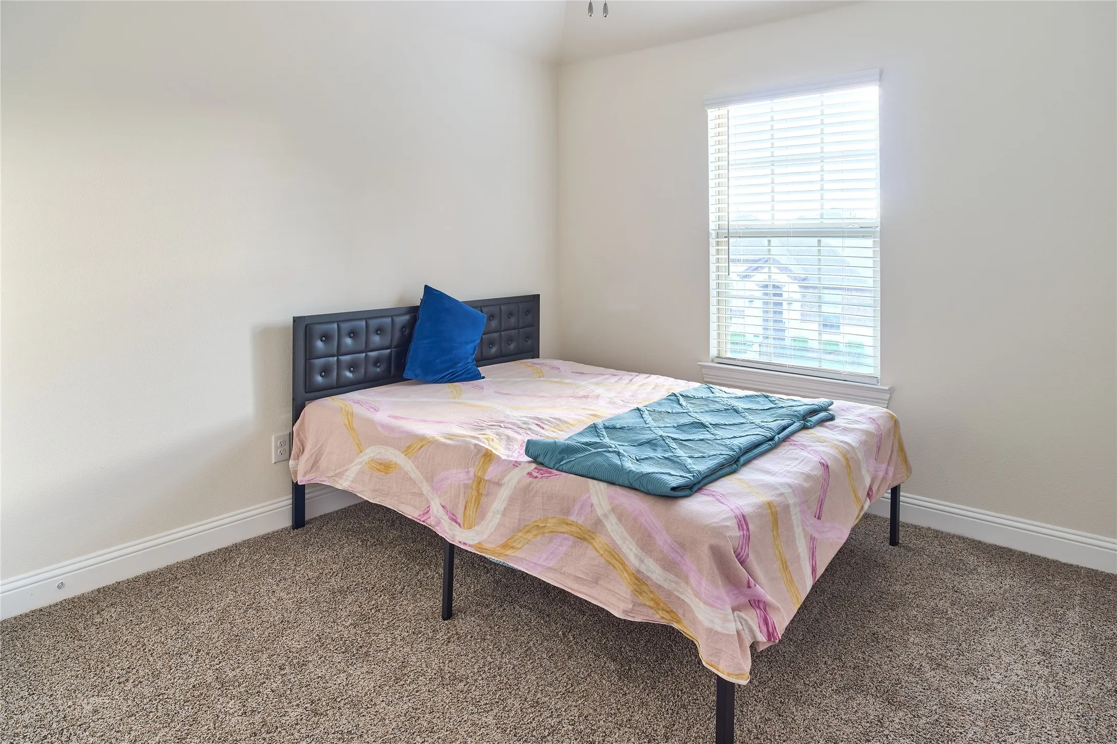 Carpeted room featuring light-colored walls and a window with blinds