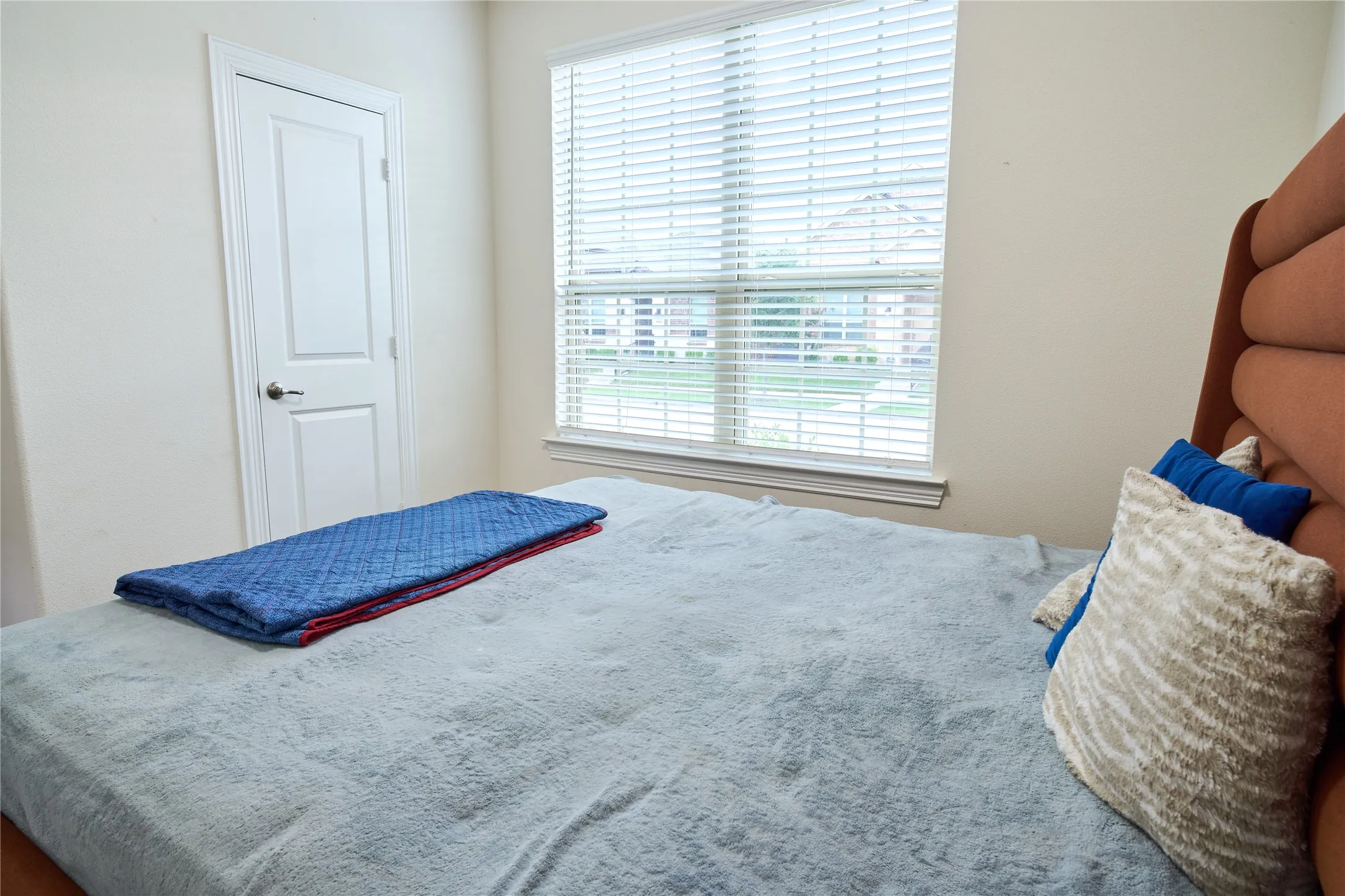 Bedroom featuring neutral wall tones and a window with blinds