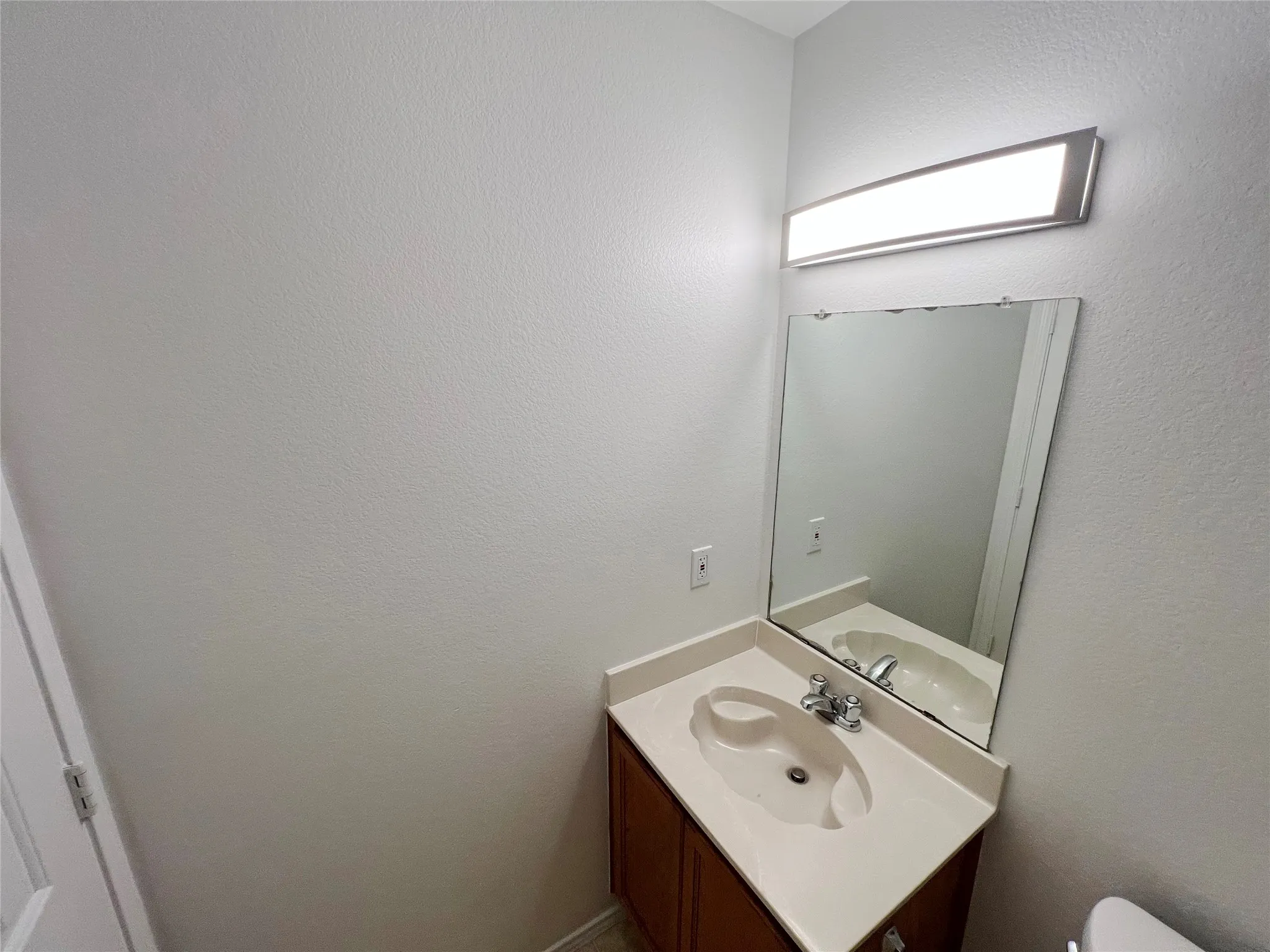 Bathroom vanity featuring a built-in sink, chrome faucet, and integrated countertop