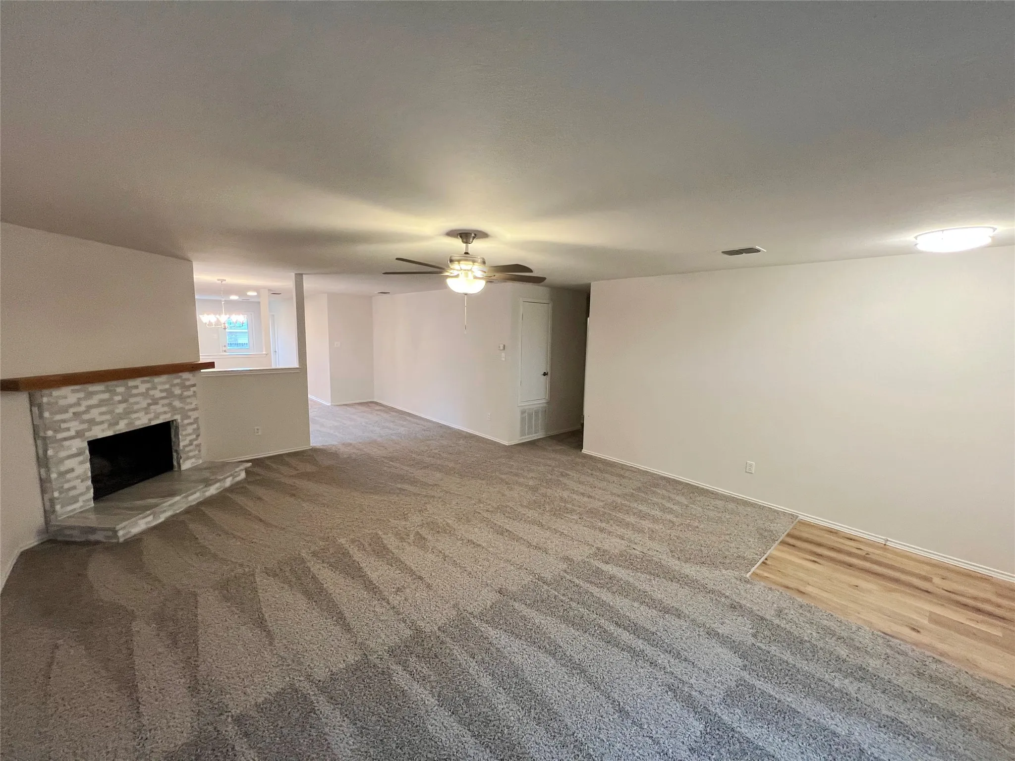 Expansive living area with a decorative fireplace featuring a tile surround and a wood mantel