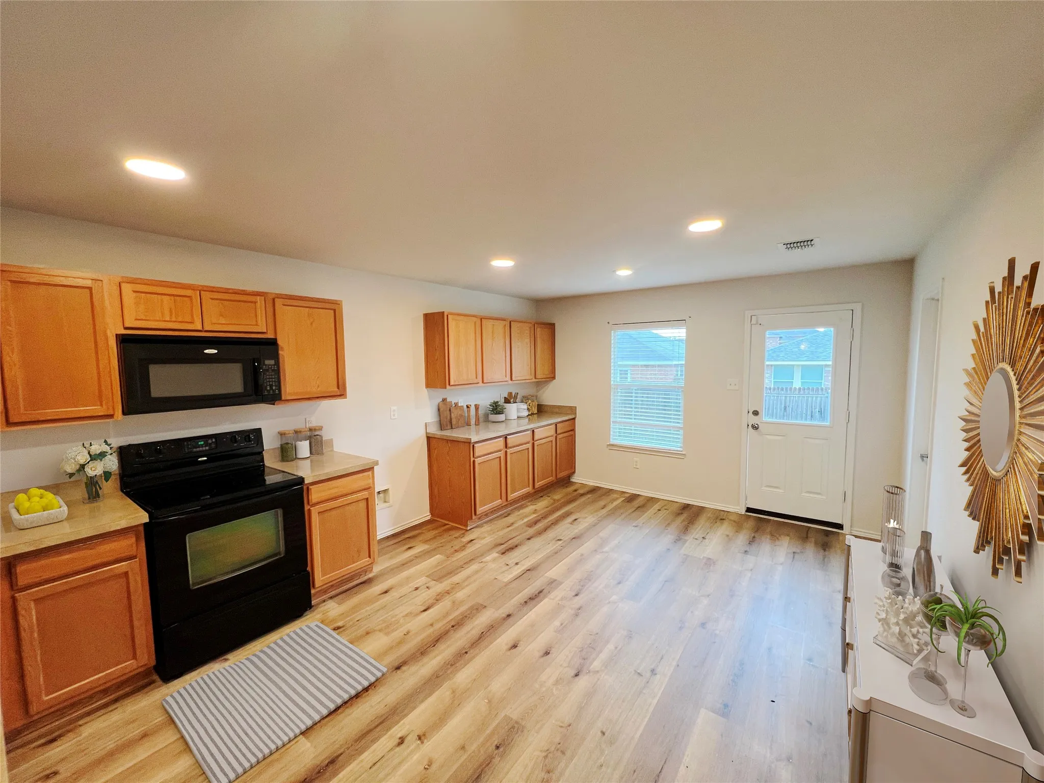 Kitchen area featuring wood-finish flooring, recessed lighting, and honey-toned cabinetry