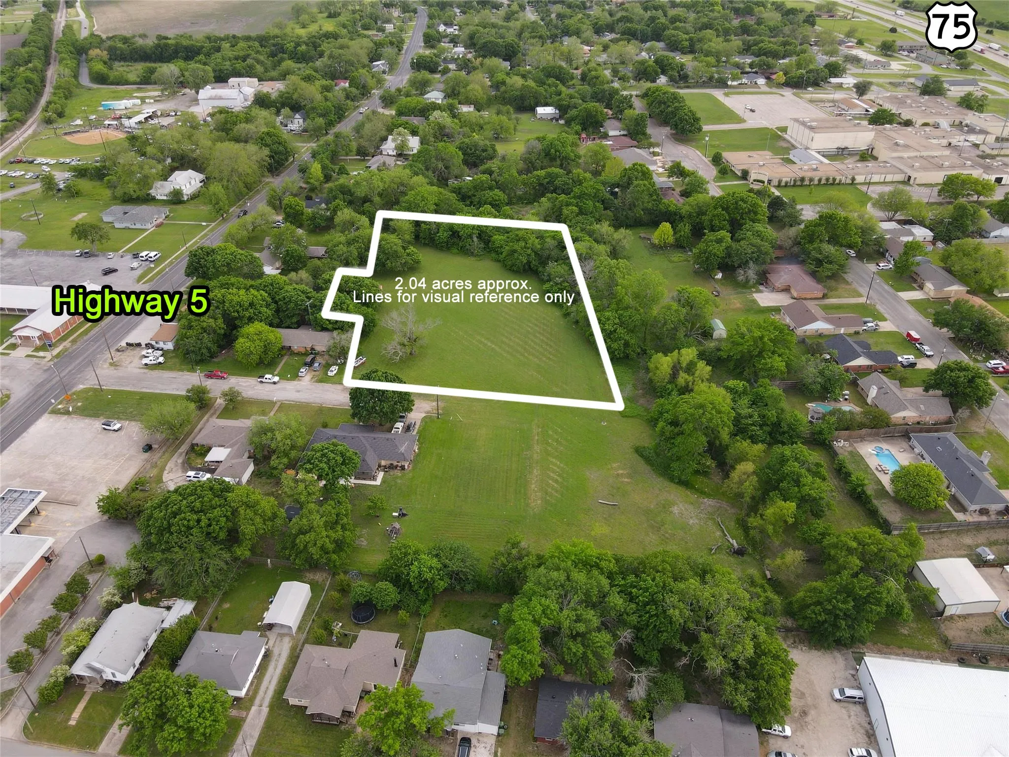 Expansive 2.04-acre parcel with surrounding mature trees and open green spaces