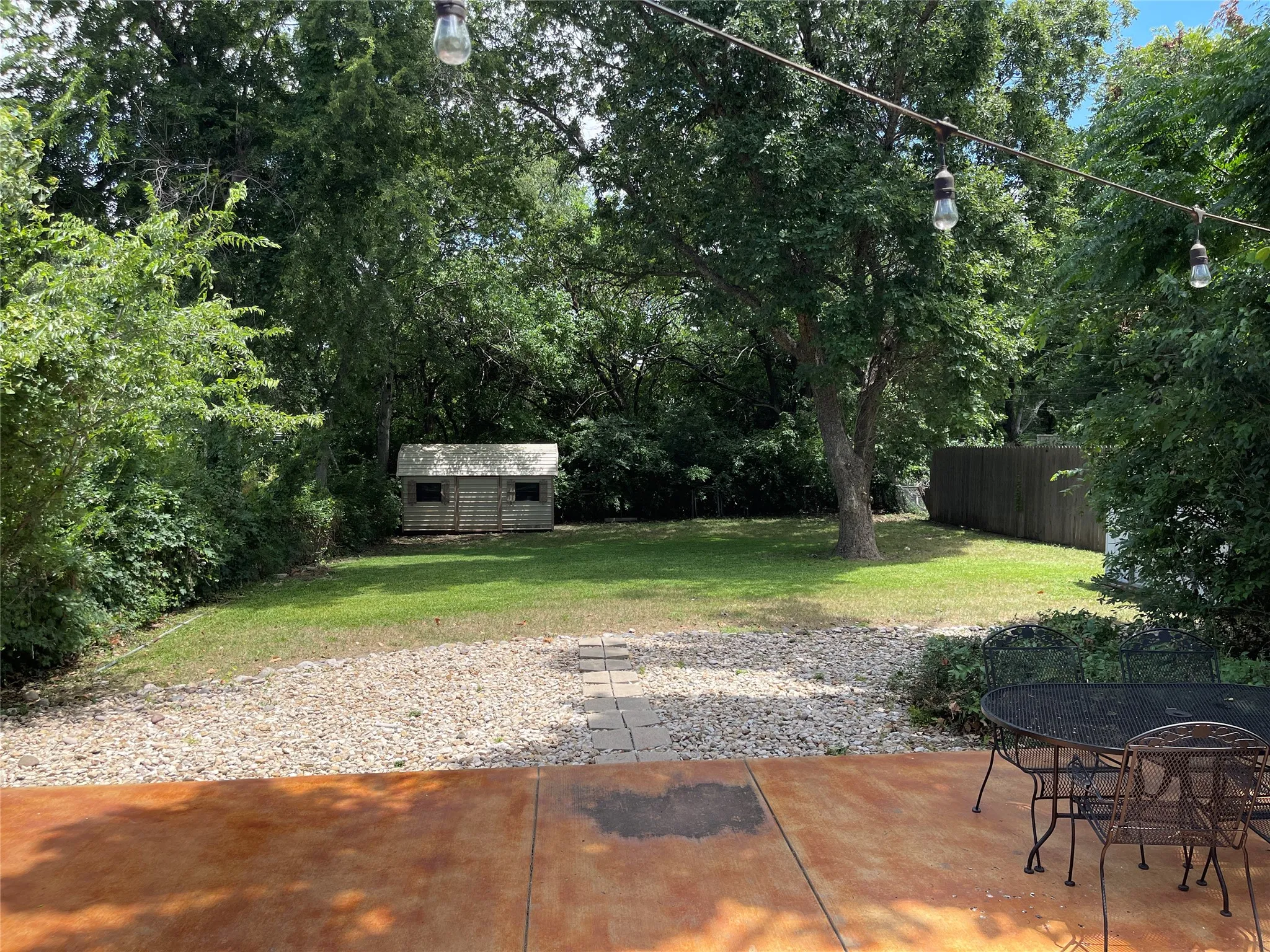 Spacious backyard shade trees.  Huge open air concrete patio and wood deck.  Two storage buildings on either side of this almost 1/3 acre lot.