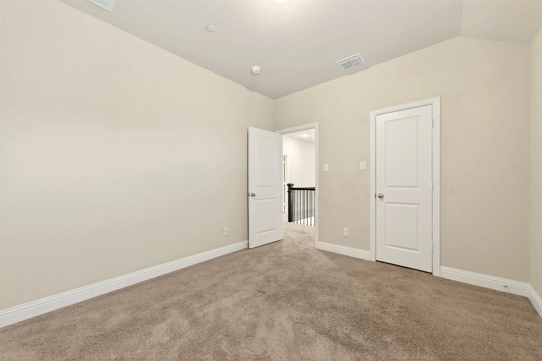 Carpeted room with vaulted ceiling and recessed lighting
