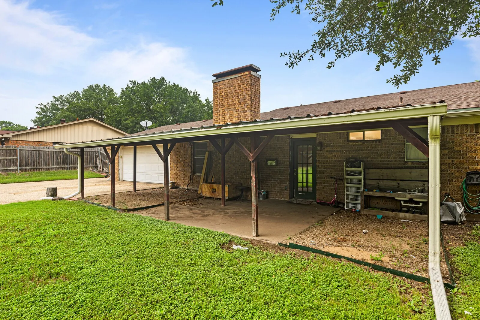 Expansive covered patio featuring a concrete slab and wood support beams