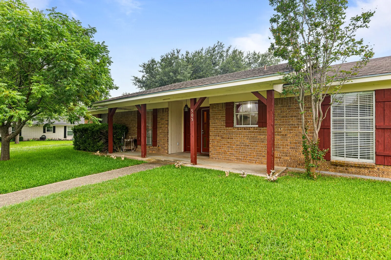 Brick facade with a covered porch featuring wood posts