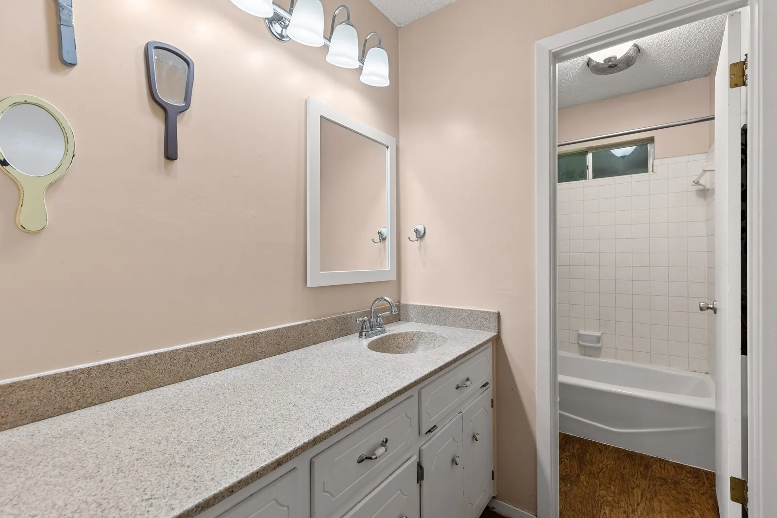 Extended vanity with a built-in sink, framed mirror, and chrome light fixture