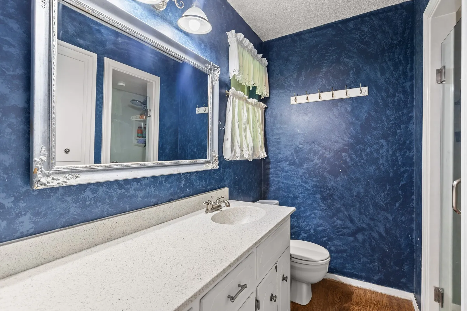 Bathroom featuring a white vanity with a light-toned countertop, an undermount sink, and brushed nickel fixtures