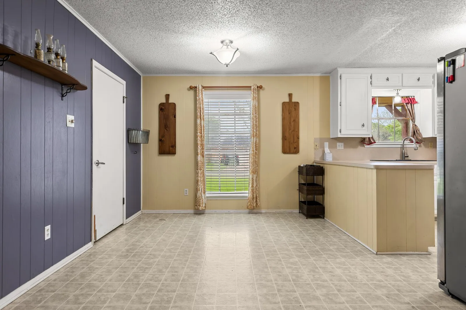 Kitchen area featuring white cabinetry, a double basin sink, and a light-colored countertop