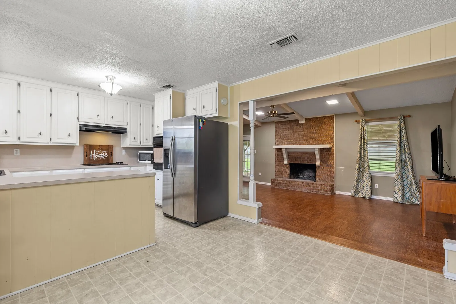 Kitchen with white cabinetry and a built-in oven, featuring a bar-height countertop