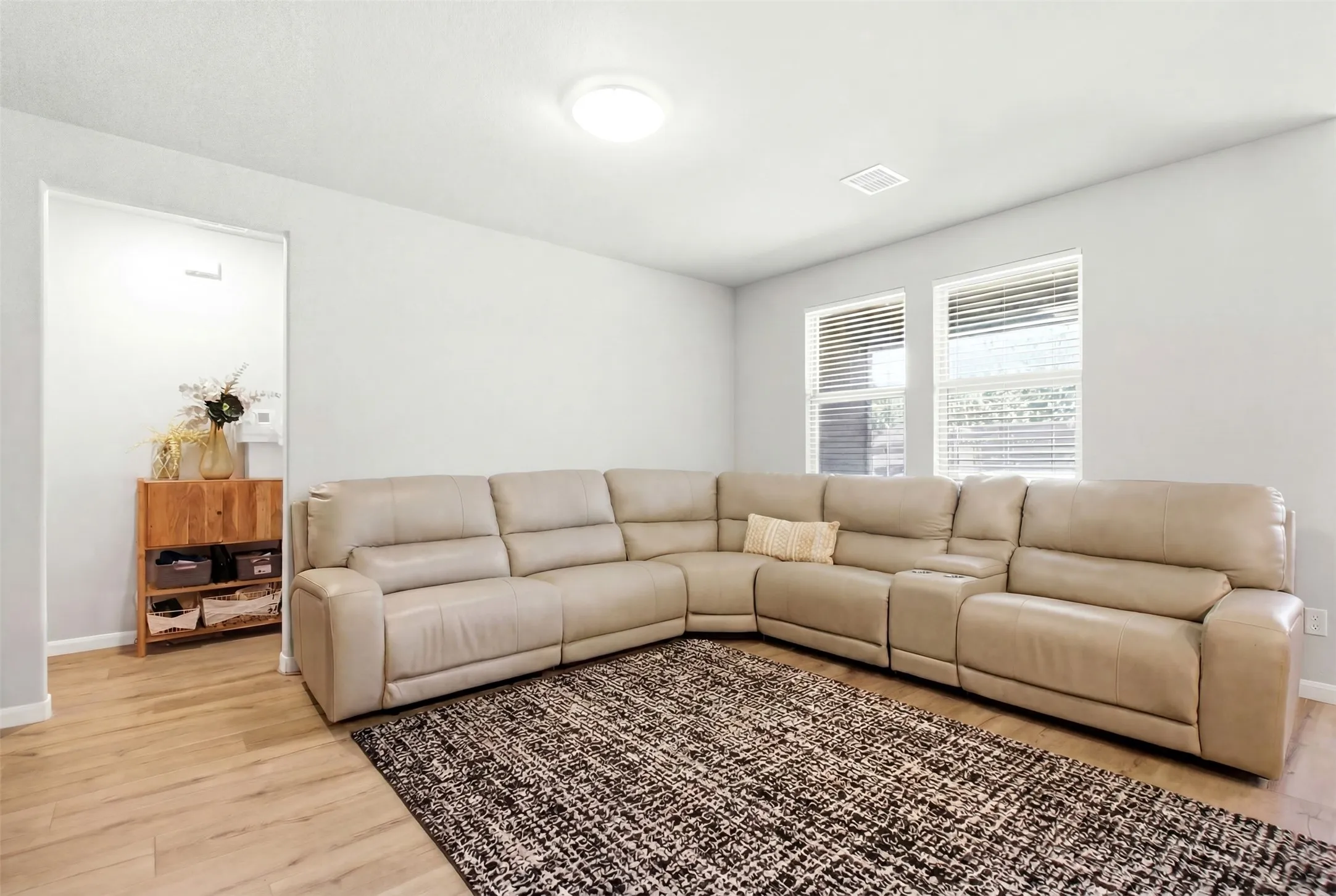 Spacious room featuring light wood-finish flooring and neutral wall tones