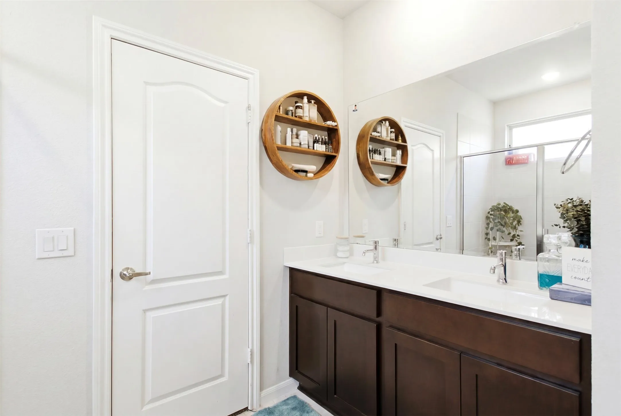 Bathroom featuring a dual-sink vanity with white countertops and dark wood-finish cabinetry