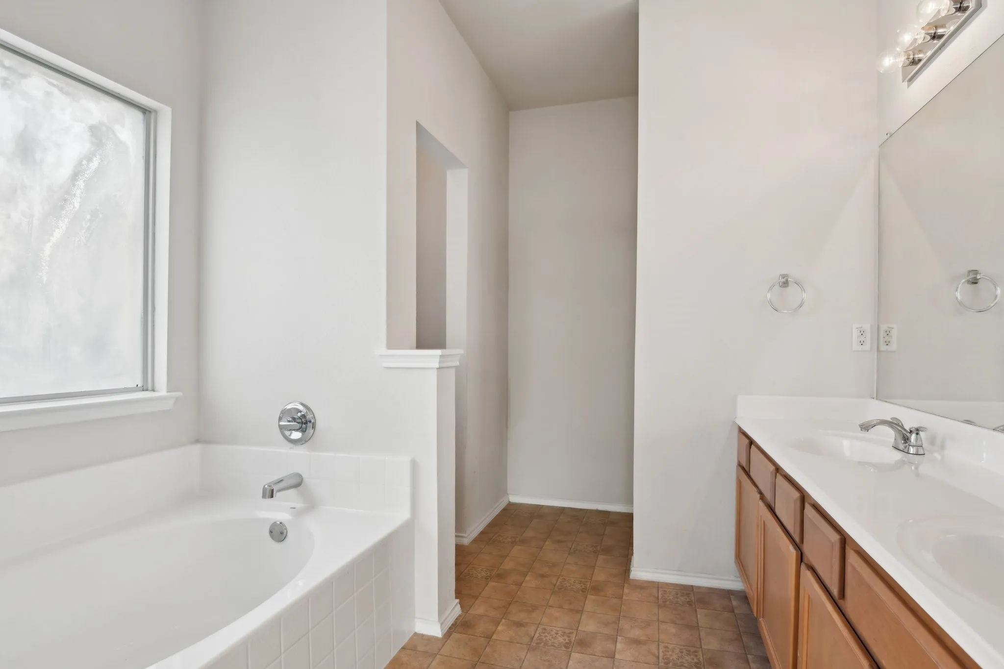 Bathroom with vanity and tiled bath, and separate tub