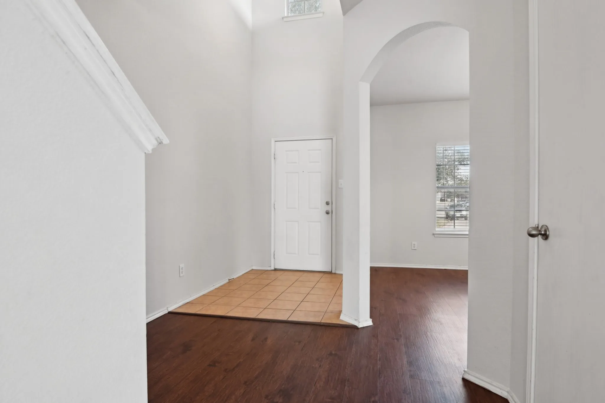 Foyer entrance with hardwood / wood-style flooring and a towering ceiling
