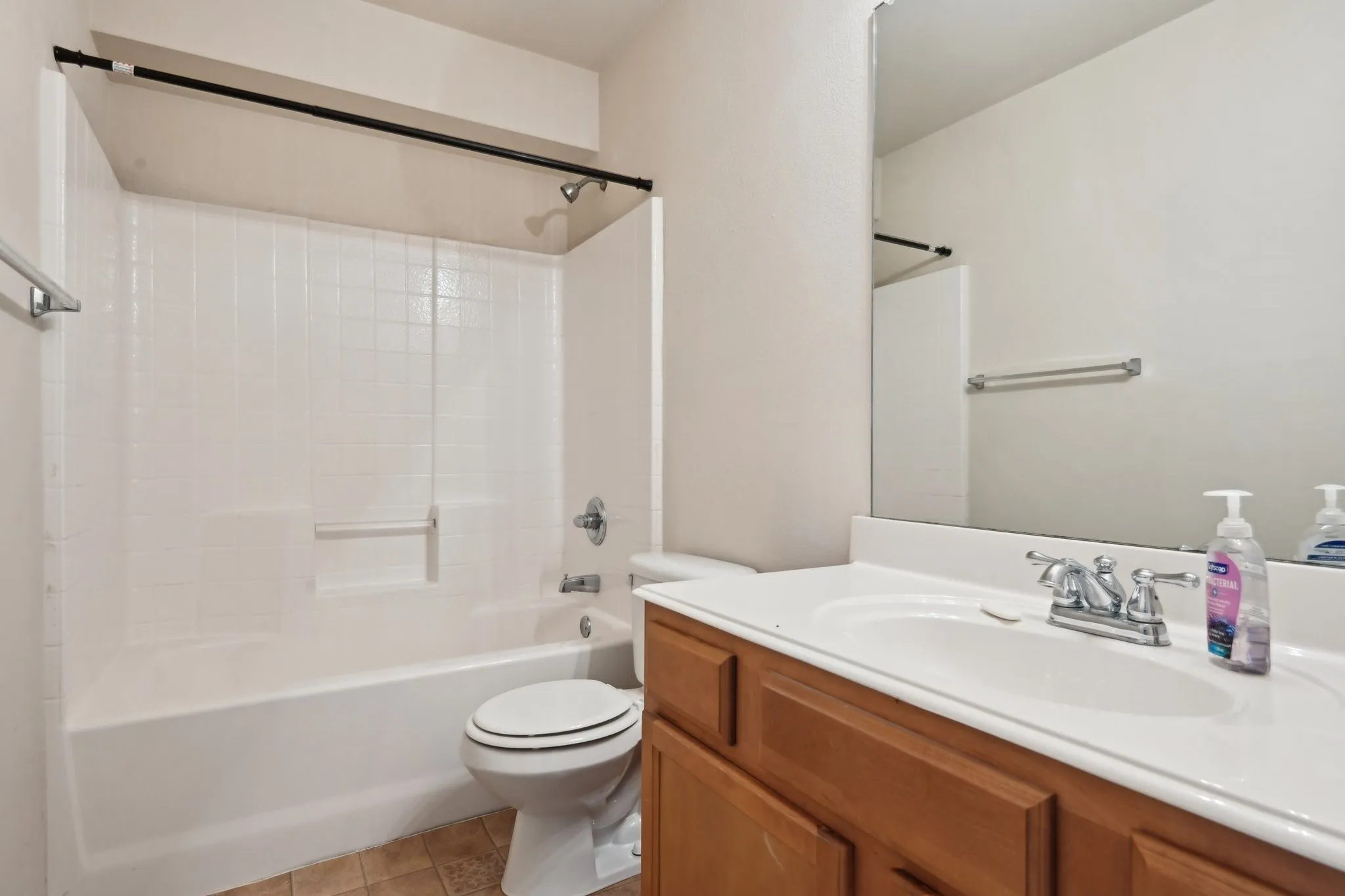 Full bathroom with vanity, toilet, tile patterned flooring, and shower / bathing tub combination