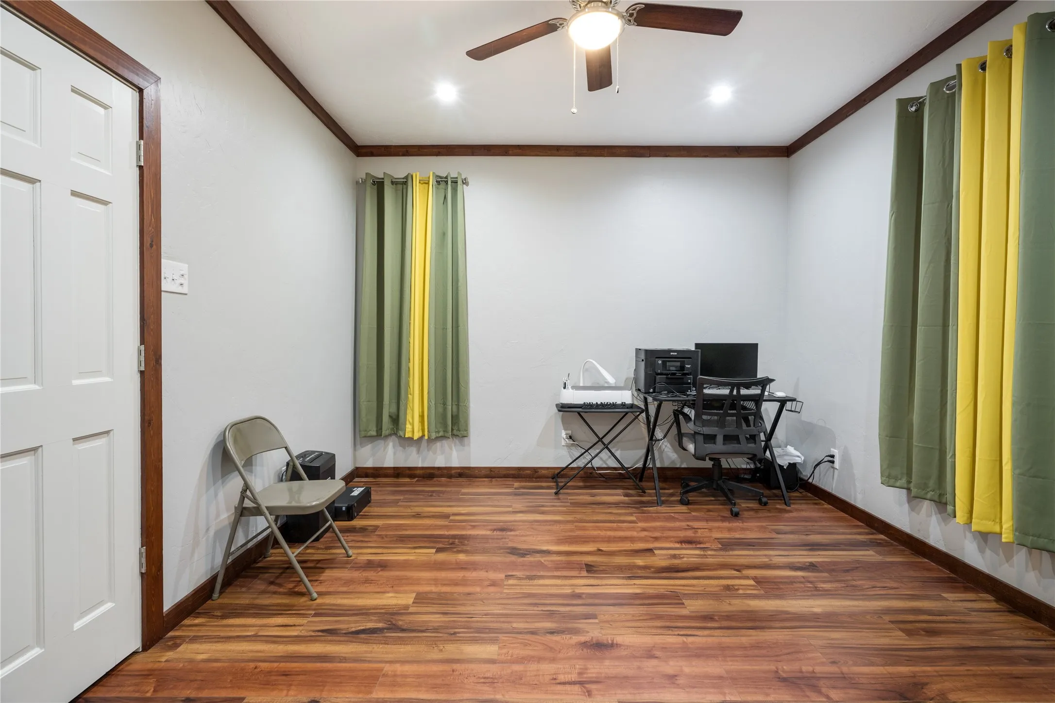 Room featuring wood-finish flooring, white walls, and dark wood trim