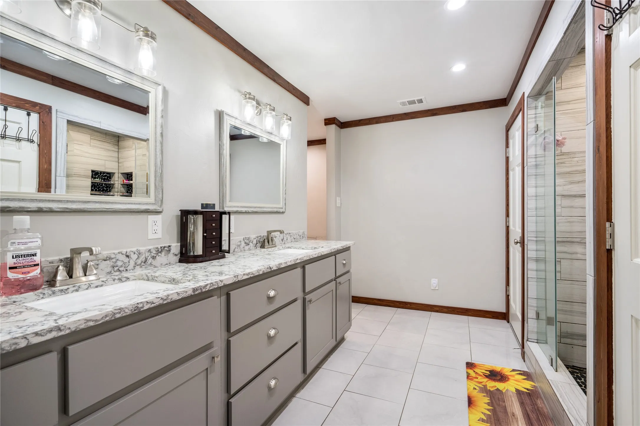 Dual vanity with gray cabinetry, white countertops, and brushed nickel fixtures