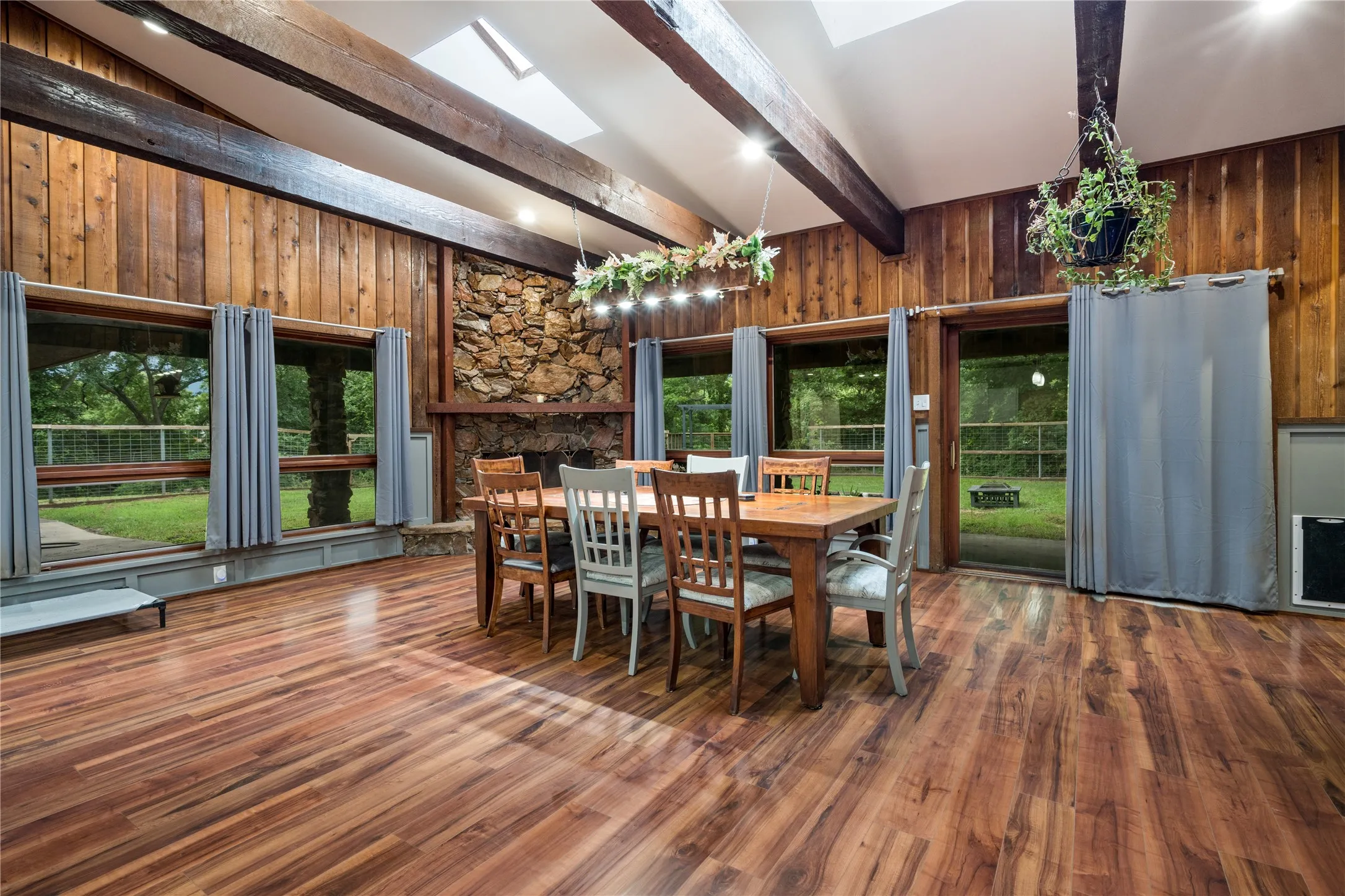 Vaulted ceiling featuring exposed wood beams and skylights
