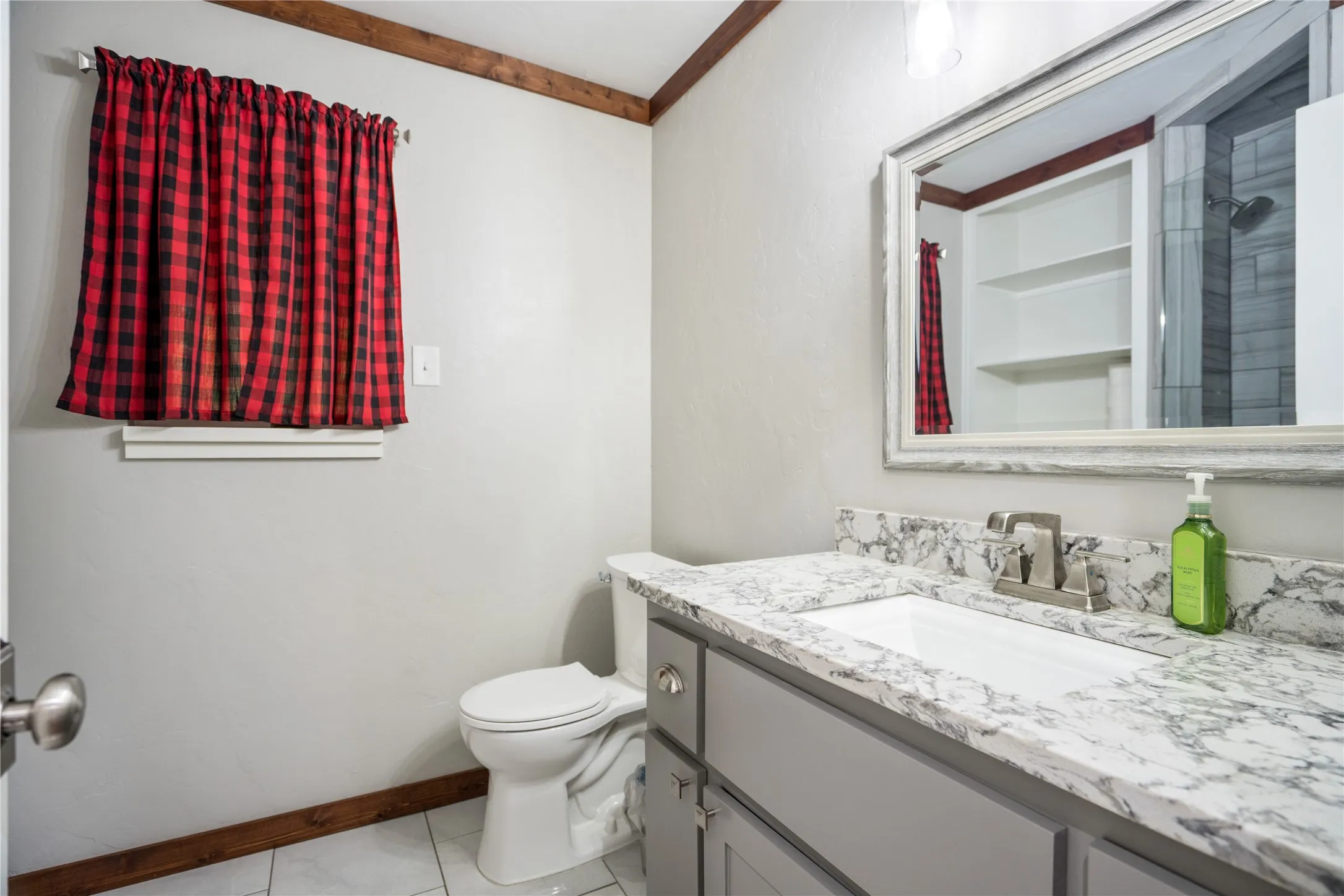 Bathroom with light gray walls and wood-finish trim
