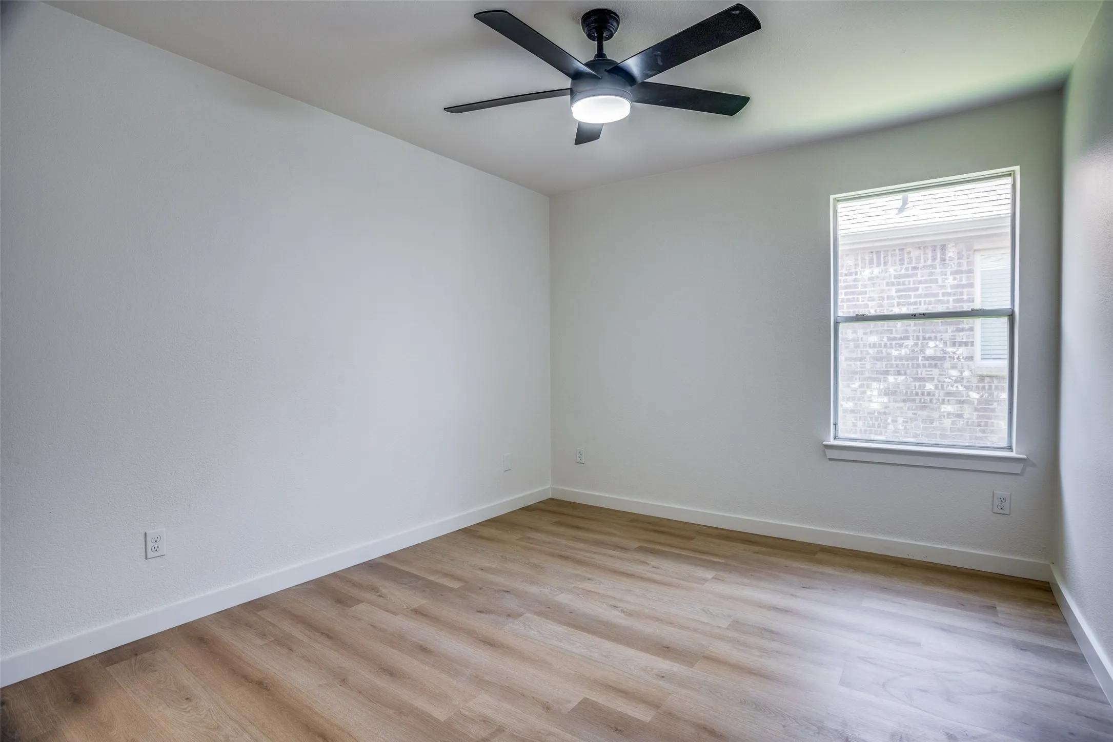 Unfurnished room with ceiling fan and light hardwood / wood-style flooring