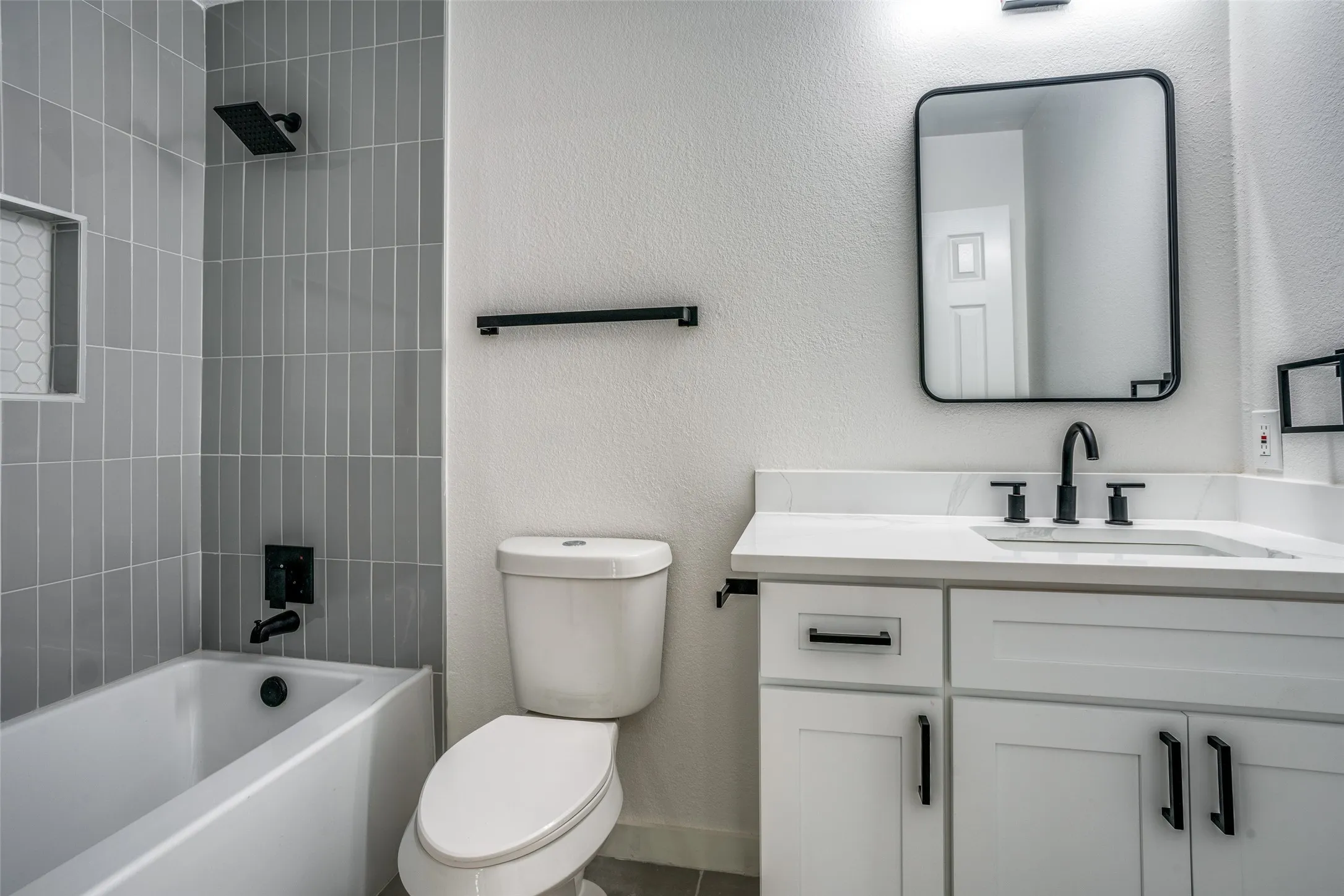 Full bathroom featuring tiled shower / bath combo, tile flooring, toilet, and vanity