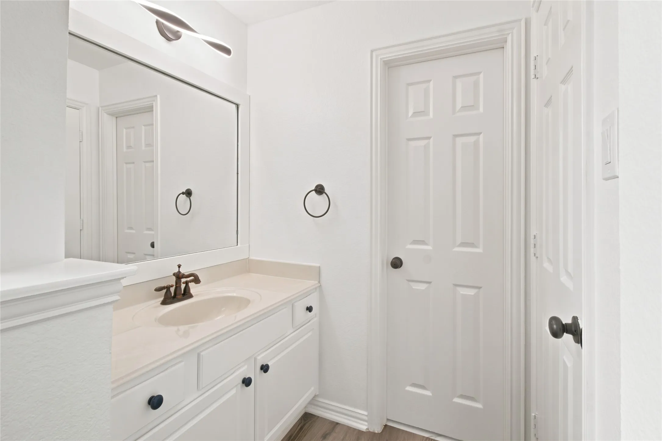 Bathroom vanity featuring a single basin, integrated countertop, and cabinet storage