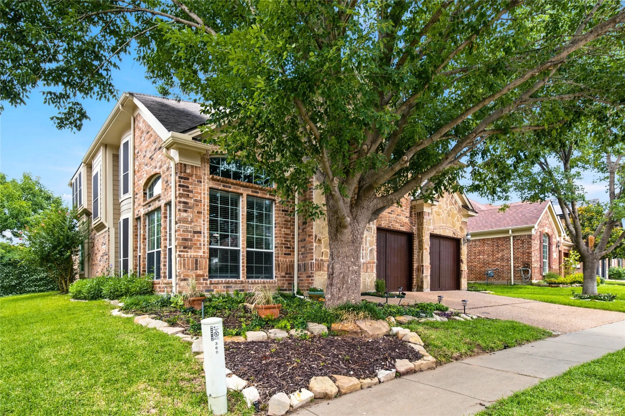 Two-story brick and stone facade residence featuring a prominent architectural bay window