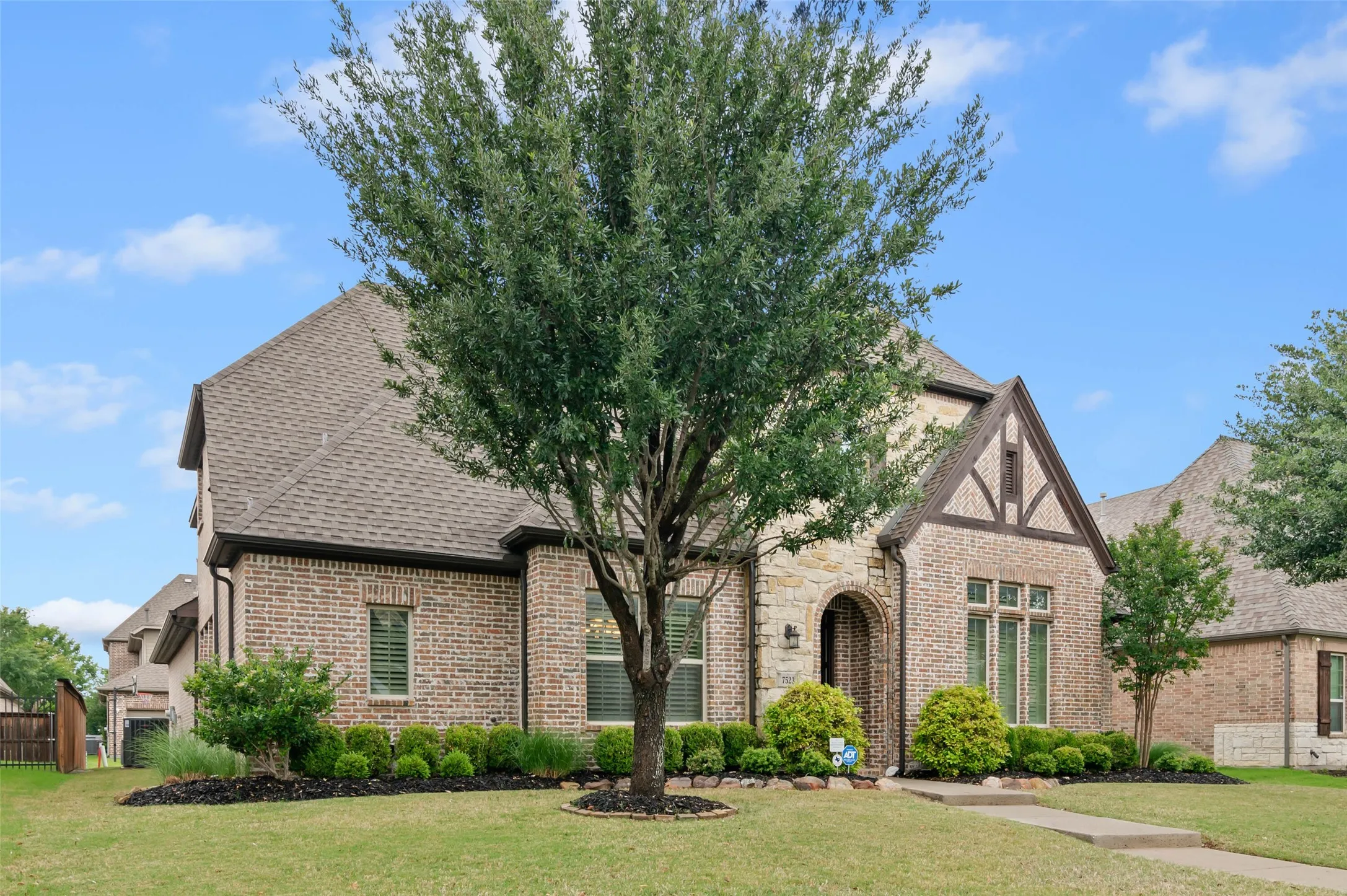Brick and stone exterior with architectural shingles and gable detailing