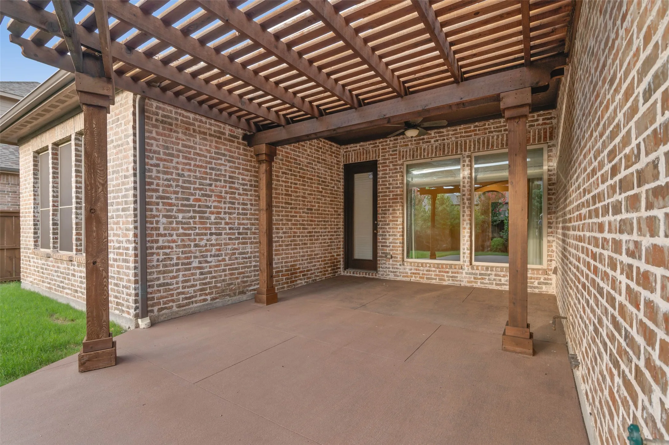 Covered patio with beautiful pergola and plenty of space for outdoor living.