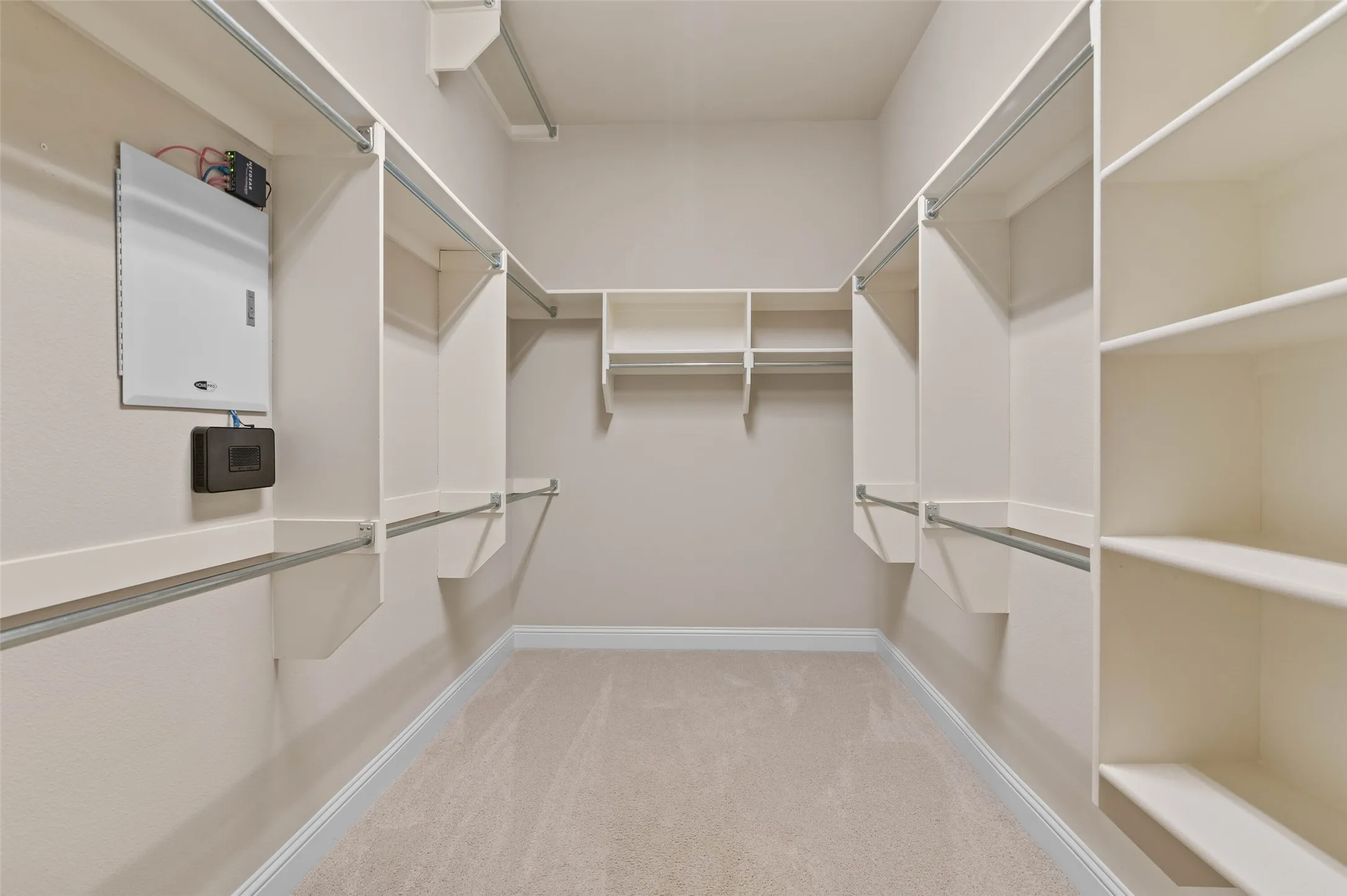 Walk-in closet featuring extensive built-in shelving, multiple hanging rods, and neutral-toned carpeting