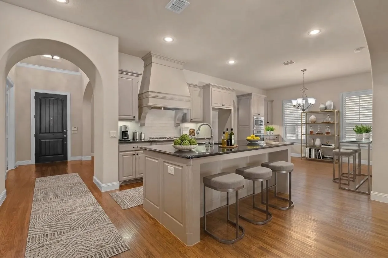 Open concept kitchen with large island, wood flooring and upgraded appliances.