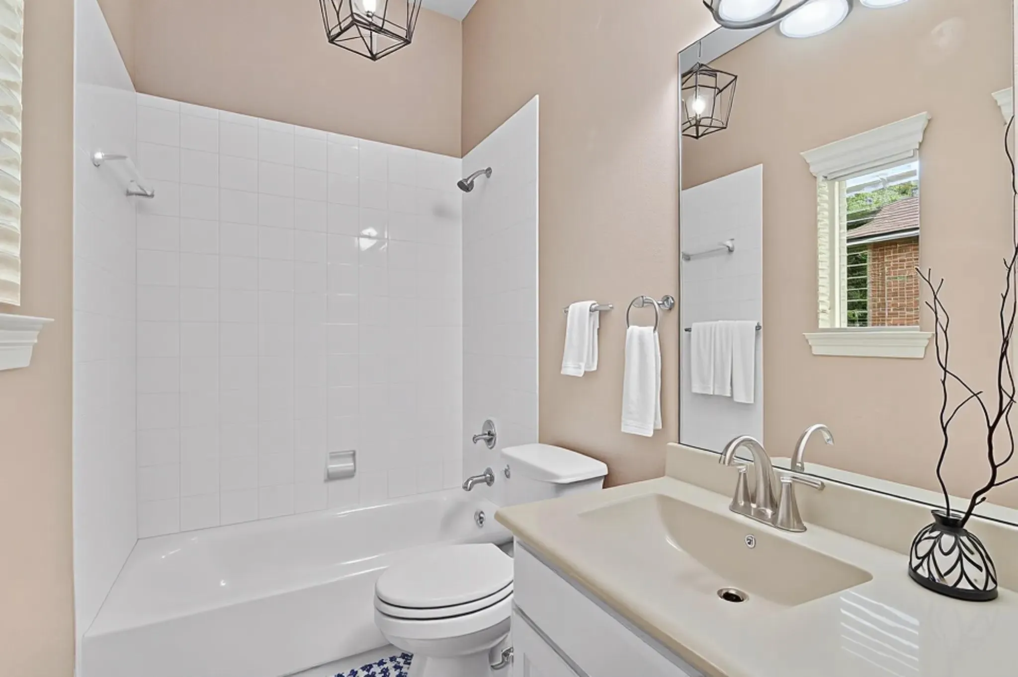 Bathroom featuring a full vanity with an integrated sink, brushed nickel faucet, and a large wall mirror