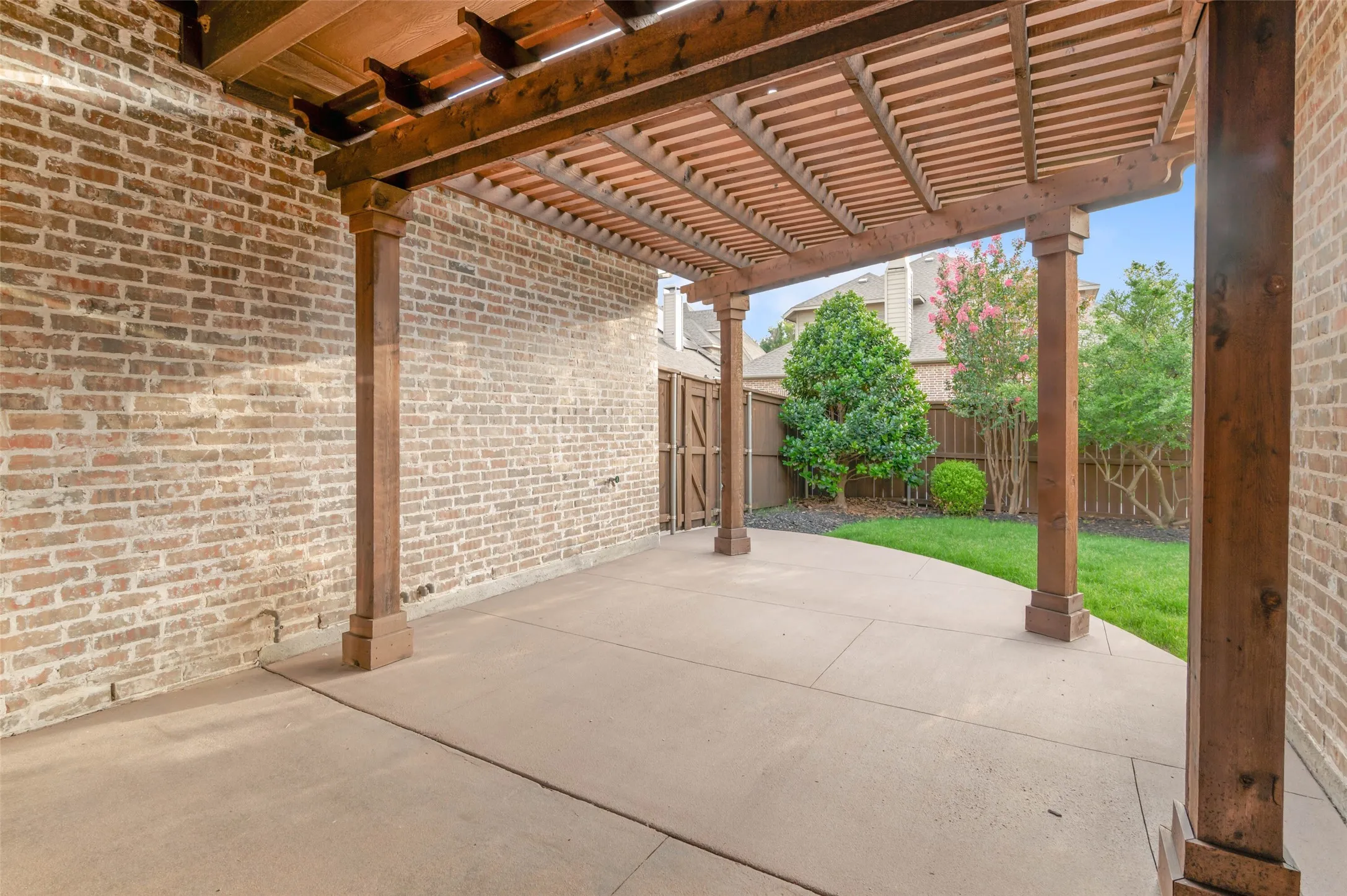 Covered patio with beautiful pergola and plenty of space for outdoor living.