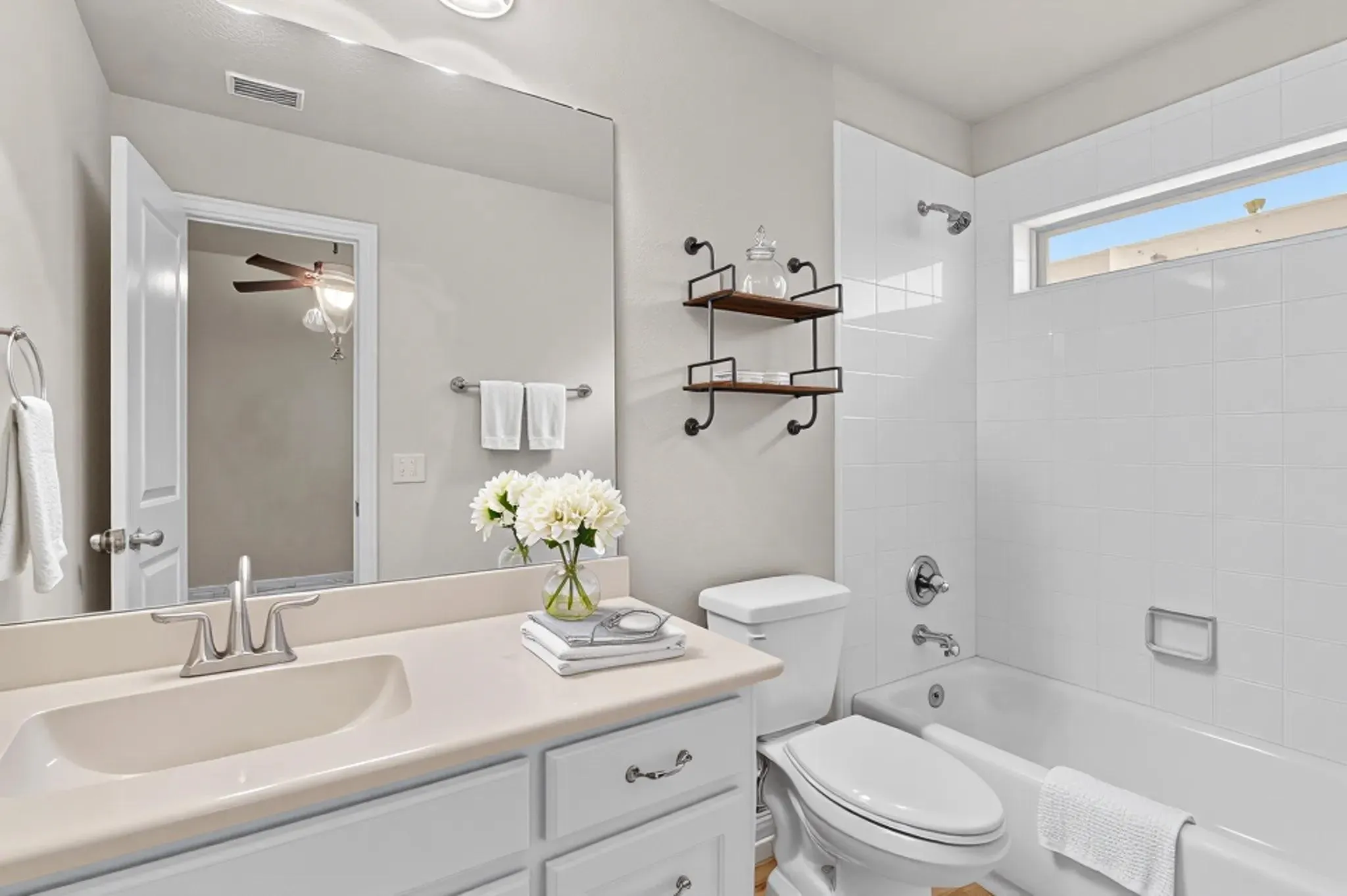 Vanity with integrated sink, chrome-finish faucet, and white cabinetry