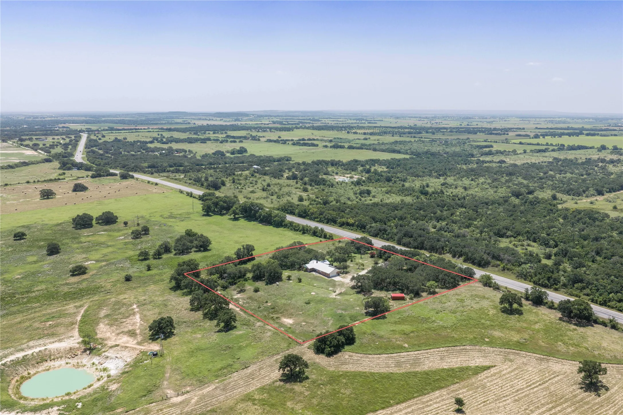 Expansive rural property featuring a single-story residence, substantial acreage with mature trees,