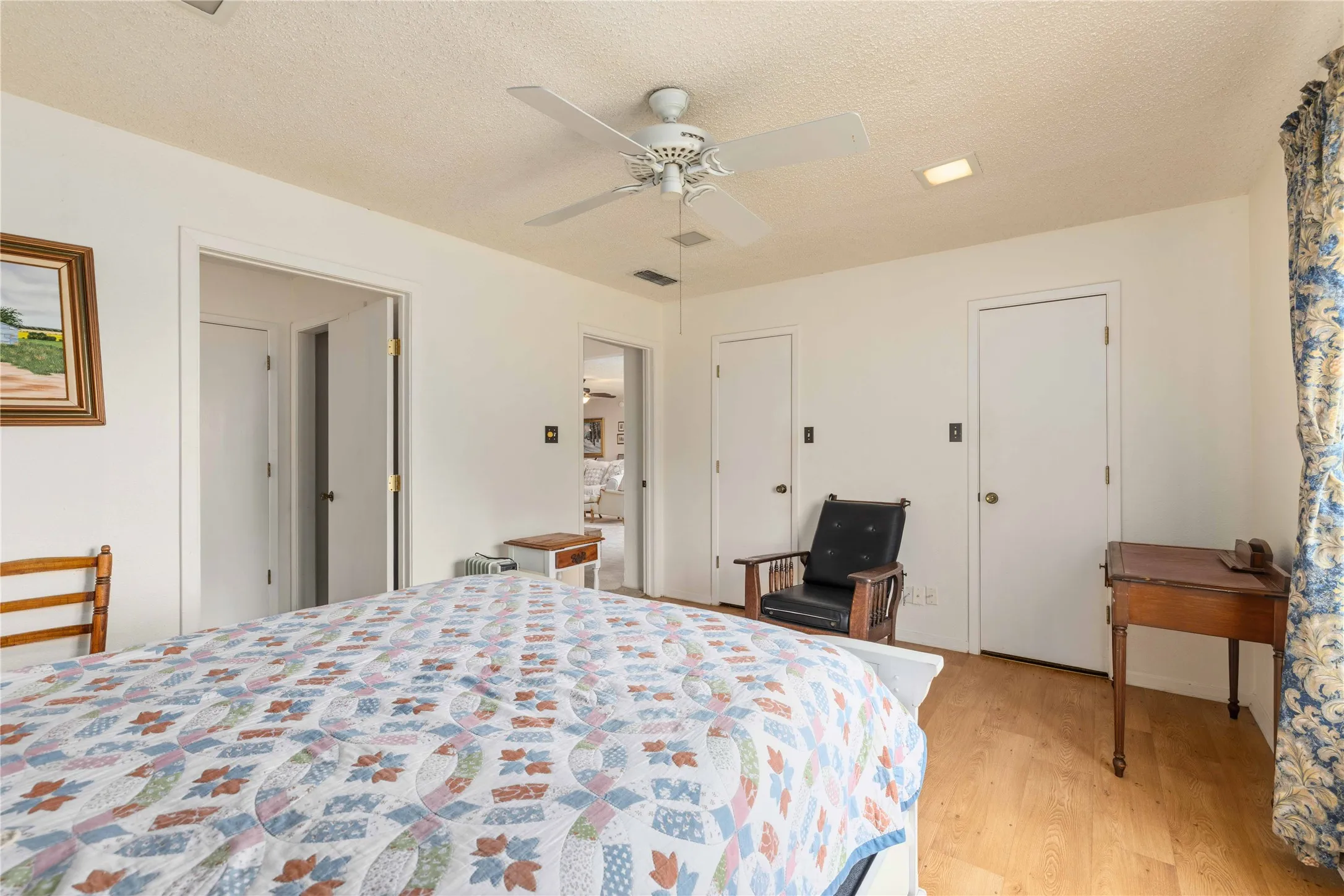 Light wood-finish flooring complements the white walls and ceiling