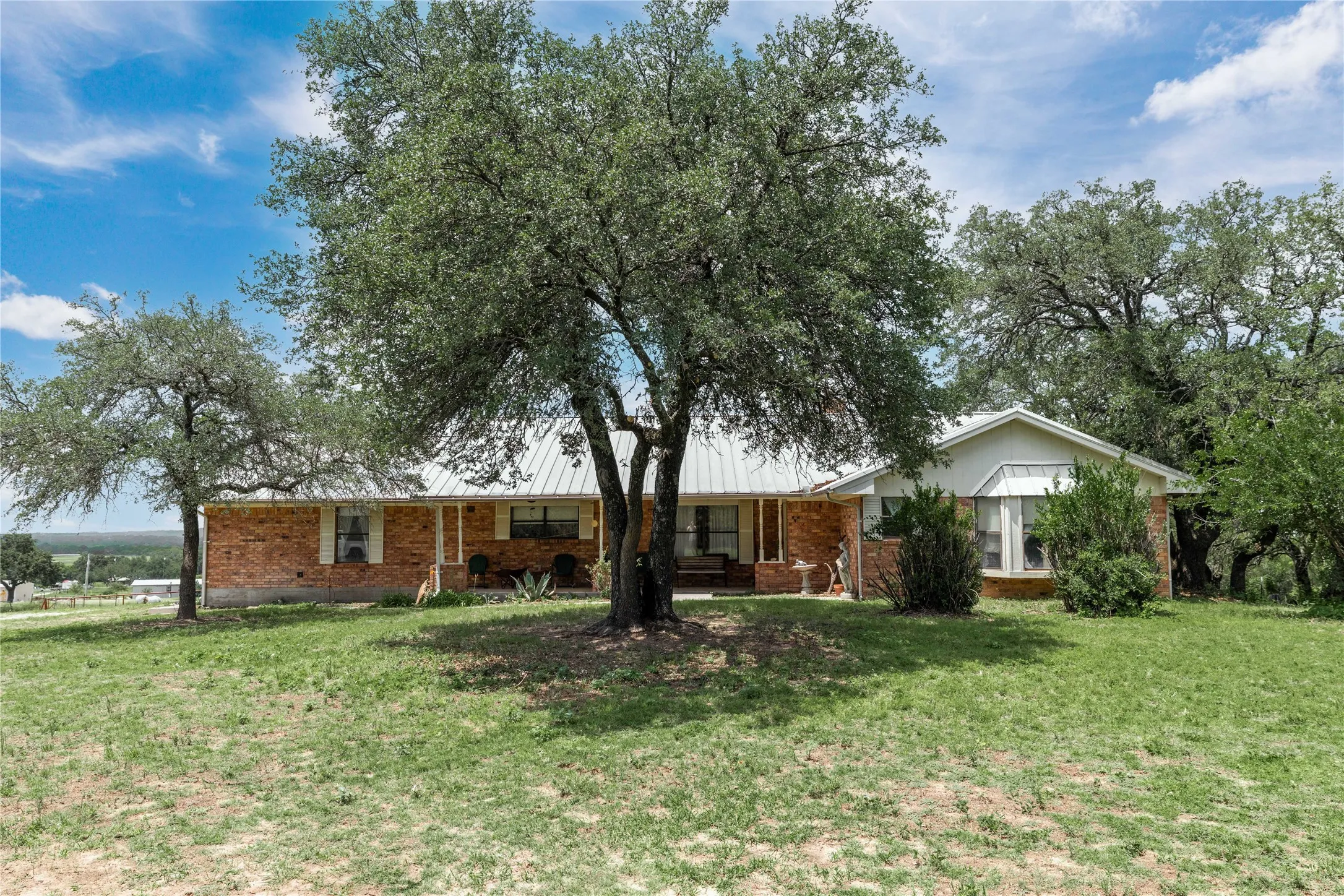 Ranch-style residence featuring a brick exterior and a metal roof