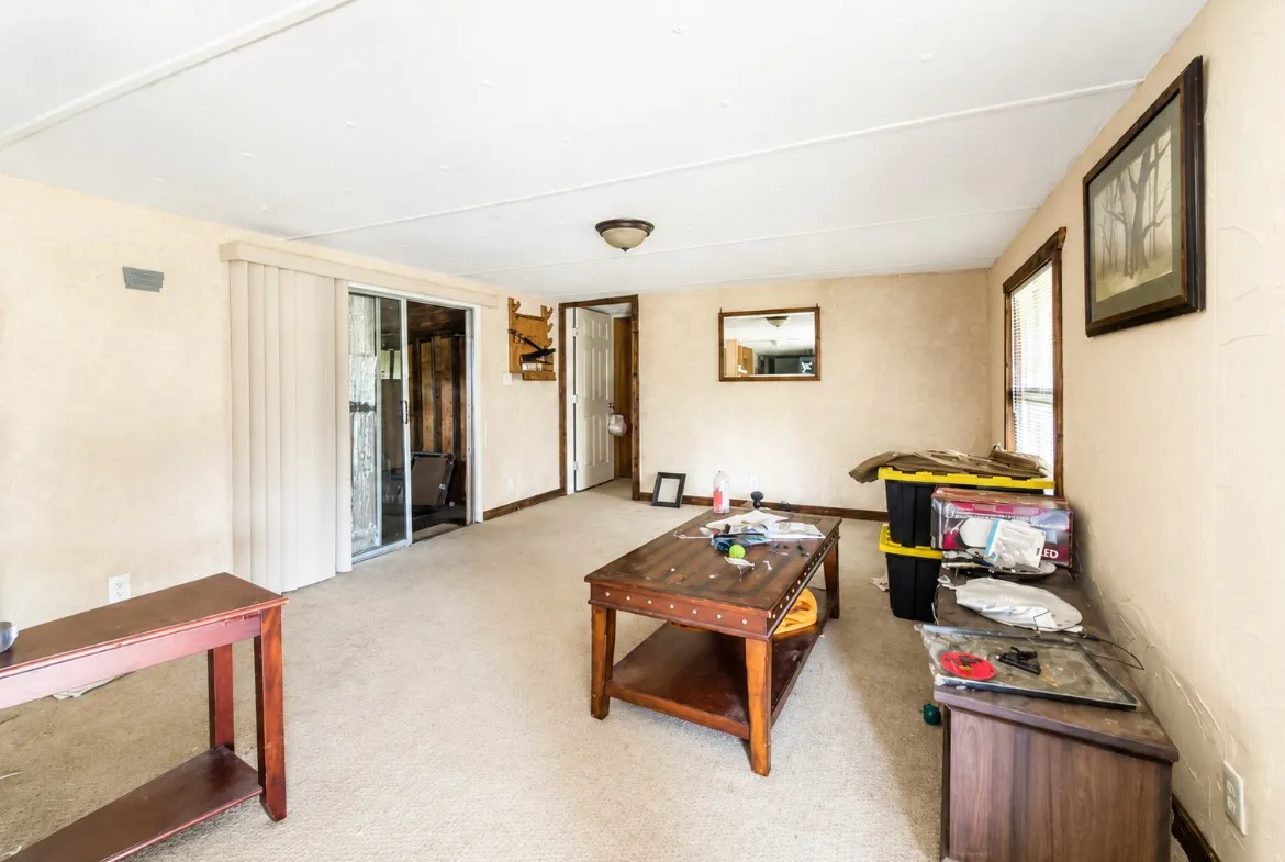 Living area with neutral-toned walls and light-colored carpeting