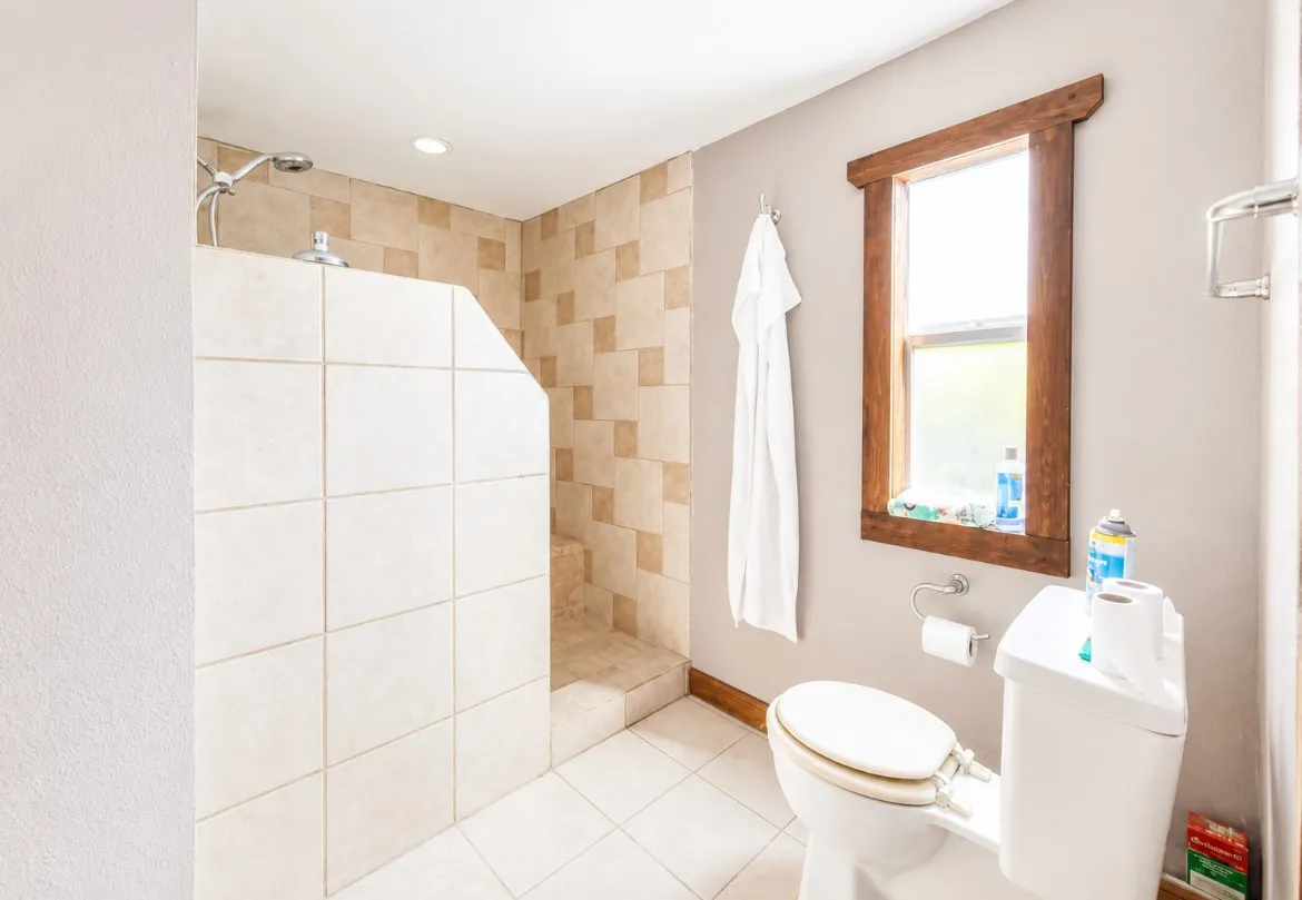 Walk-in shower with tiled walls and floor, recessed lighting, and a chrome shower head