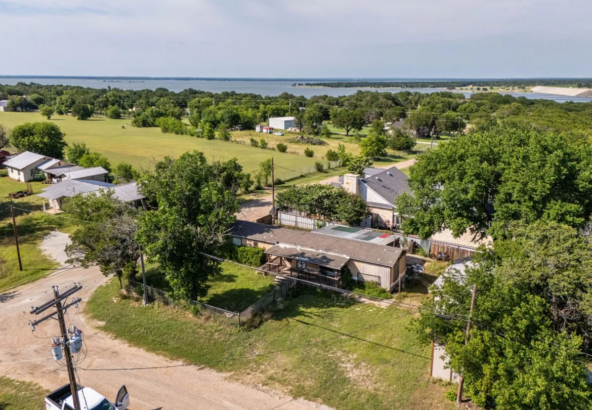 Aerial perspective showcasing expansive water body, surrounding green spaces, and diverse tree cover