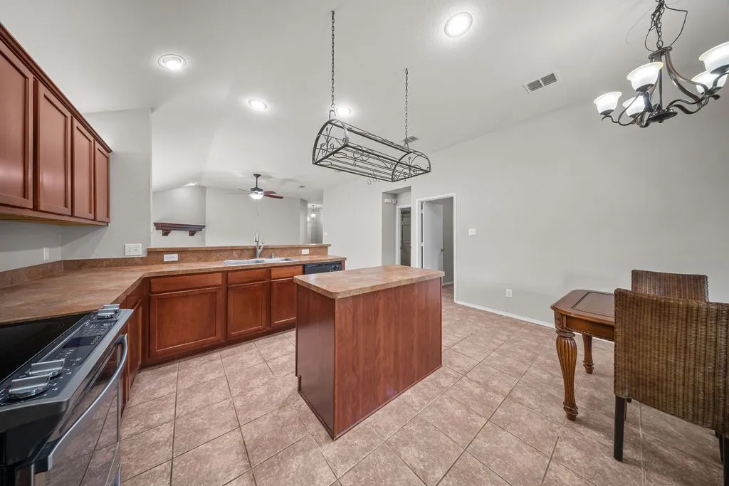 Open-concept kitchen featuring recessed lighting, a central island, and a pot rack