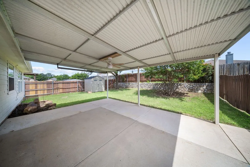 Covered patio featuring a corrugated metal roof and ceiling fan