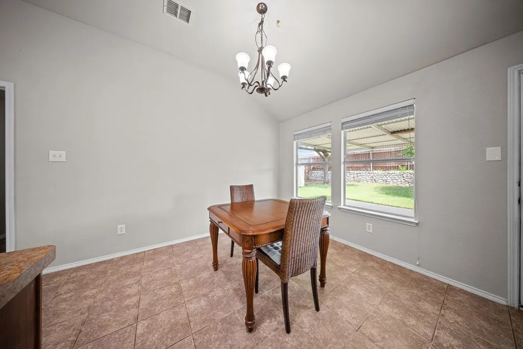 Dining area featuring vaulted ceilings, recessed lighting, and two large windows