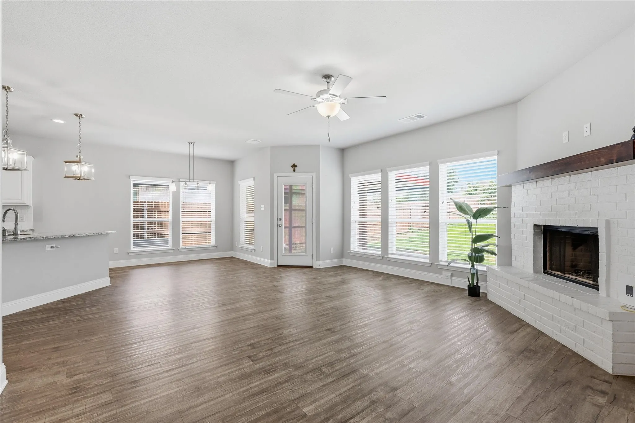 Light-filled living room offers a warm and welcoming atmosphere with a fireplace, large windows, and easy access to outdoor living spaces.