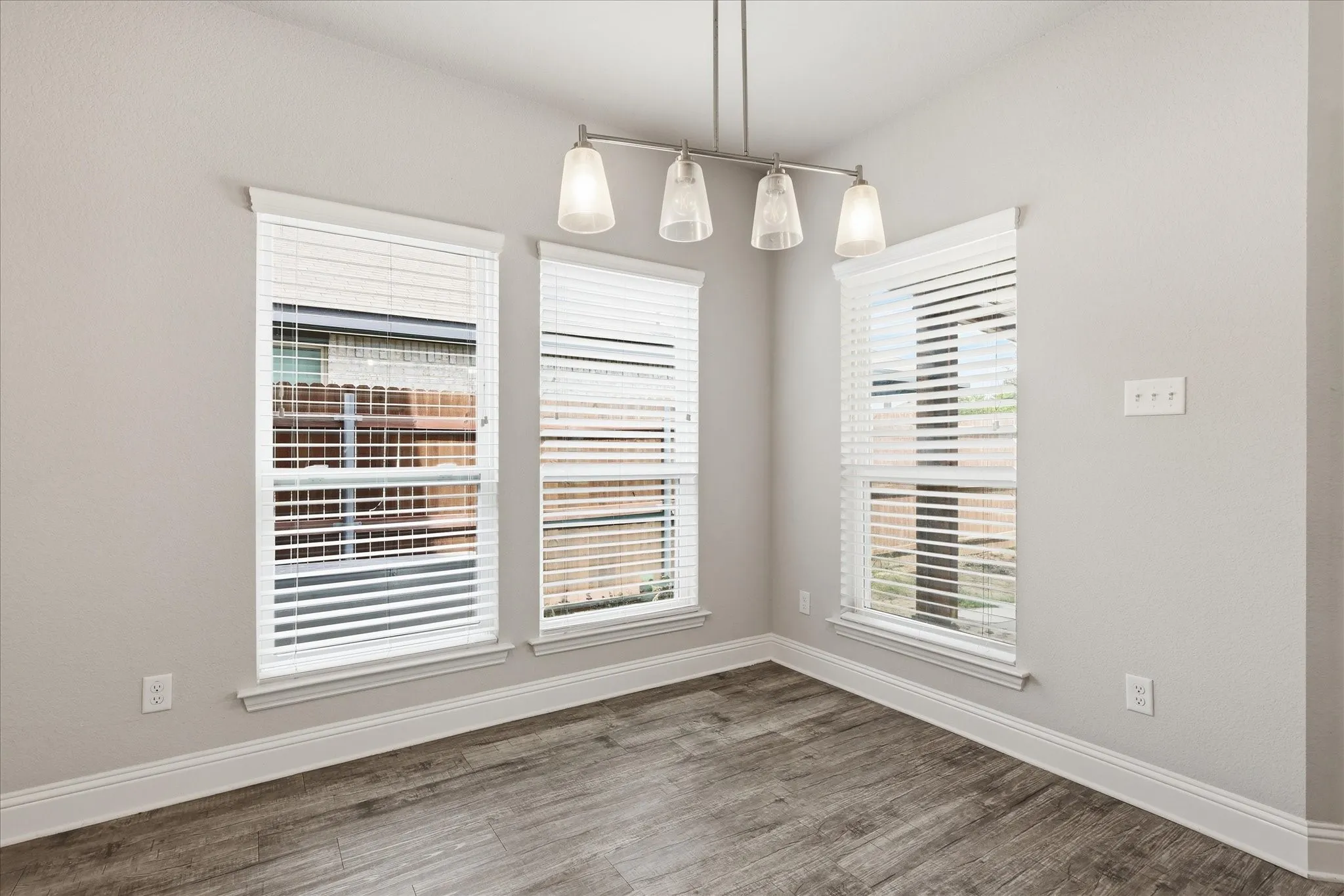 Sun-filled dining area with expansive windows, backyard views, and a welcoming atmosphere perfect for everyday living and entertaining.