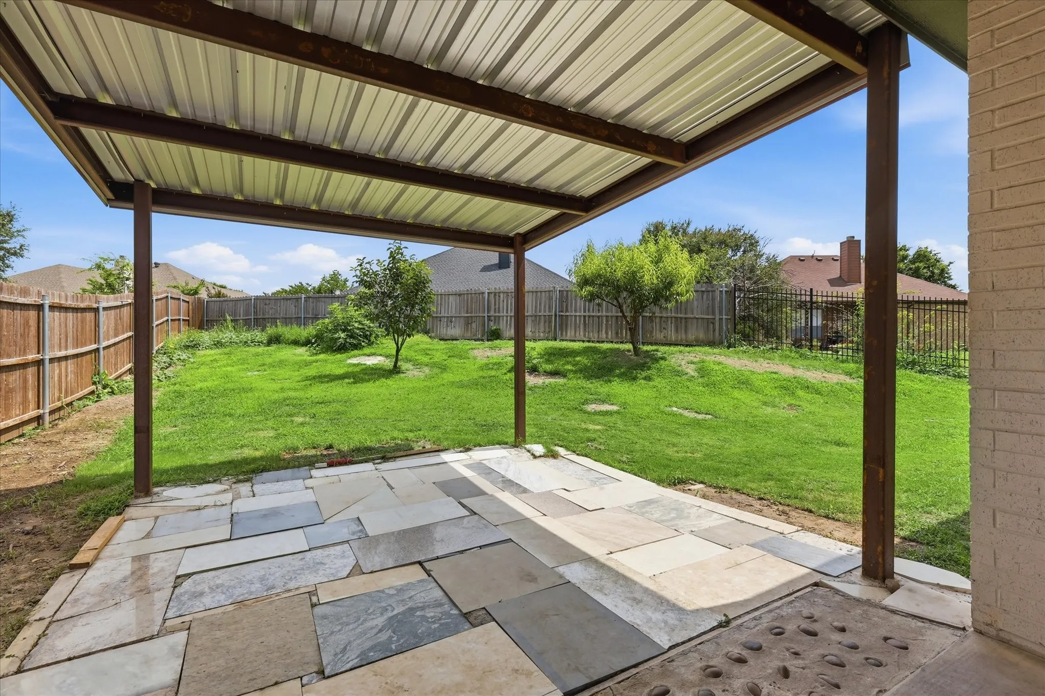 Covered patio provides the perfect space for outdoor dining, entertaining, or simply relaxing while enjoying the backyard views.