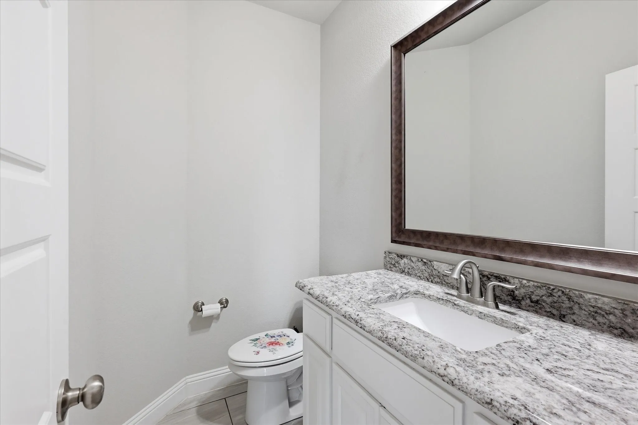 Beautifully finished powder bath with granite countertops, modern fixtures, and elegant details that enhance the home's appeal.