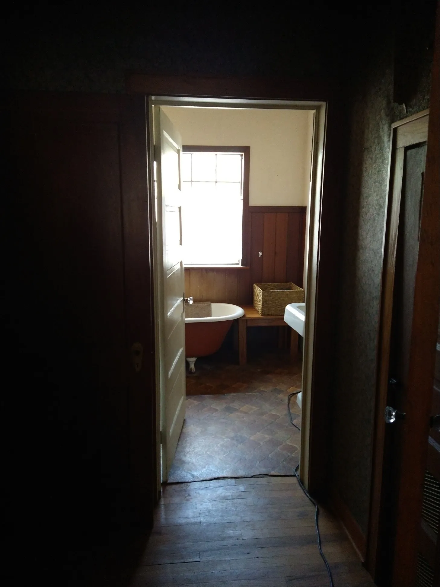 Clawfoot tub in the bathroom with a pedestal sink.
